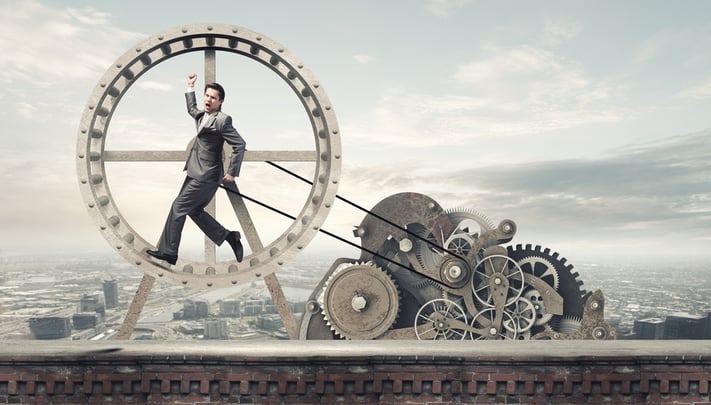 Young businessman in suit running in hamster wheel.jpeg